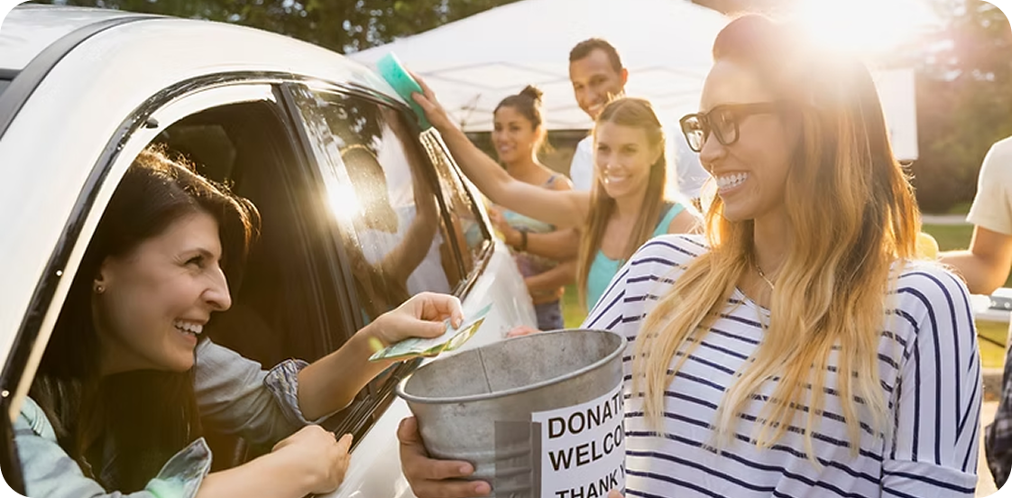 People donating money at outdoor fundraiser event.